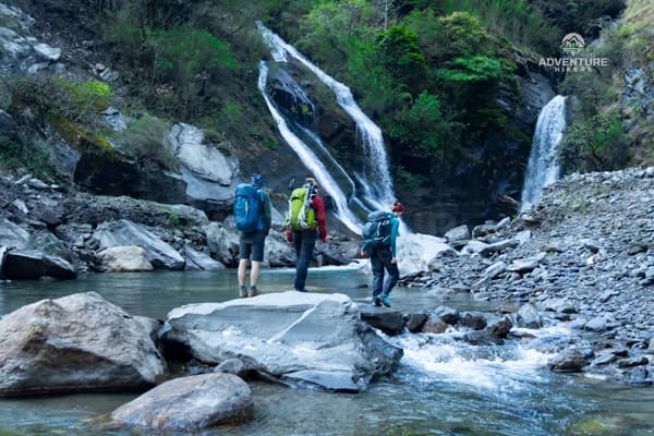 Hikers crossing the river during the Manaslu Circuit Trek in Nepal.